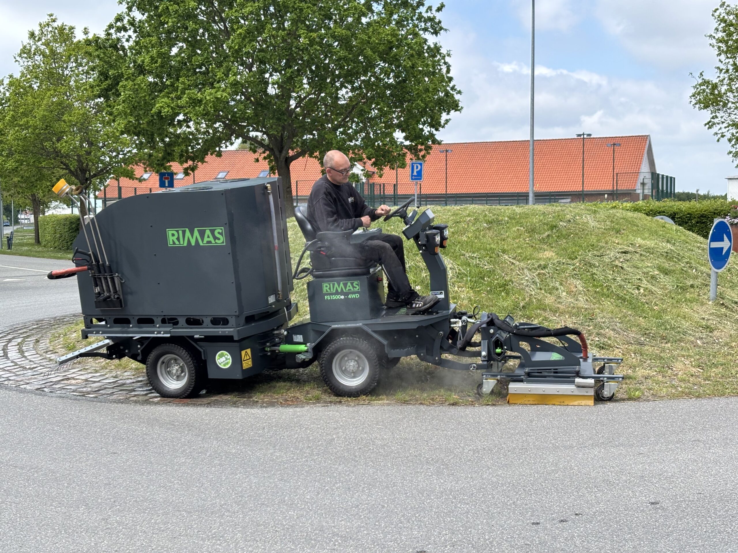 RIMAS_FS_1500e_med_varmtvandsanlæg_og_fladefordeler_kan_nemt_renholde_brosten_i_en_rundkørsel